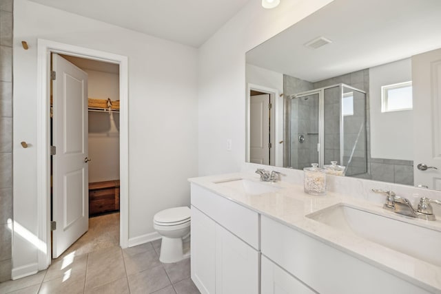 bathroom with a spacious closet, visible vents, a stall shower, and a sink