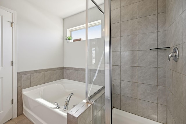 full bath featuring tile patterned floors, a stall shower, and a garden tub