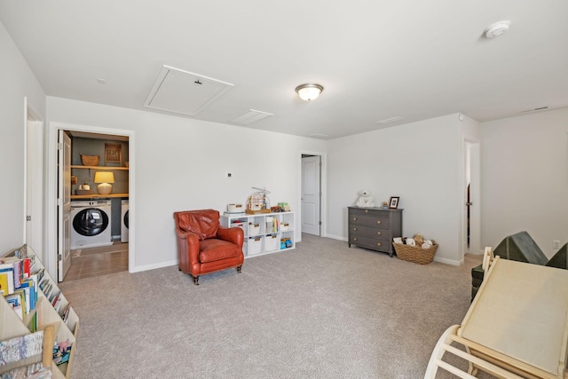 sitting room featuring baseboards, carpet, and separate washer and dryer