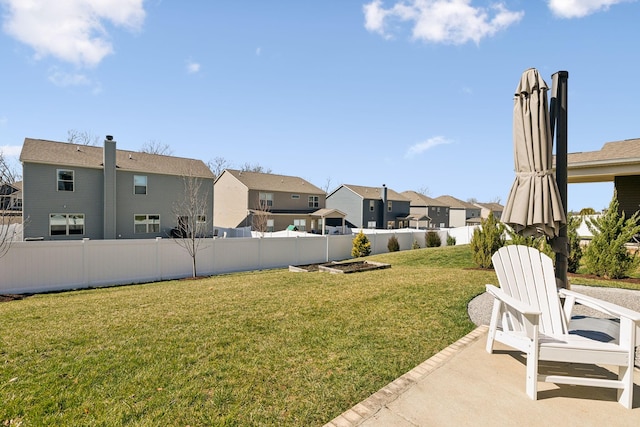 view of yard with a patio, a fenced backyard, and a residential view