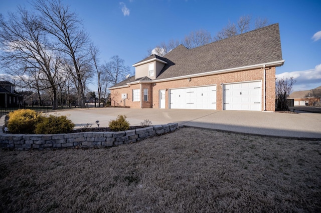 view of front facade with fence, concrete driveway, a shingled roof, a garage, and brick siding