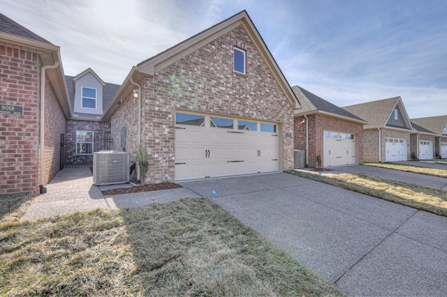 view of front of property featuring a garage, cooling unit, brick siding, and driveway