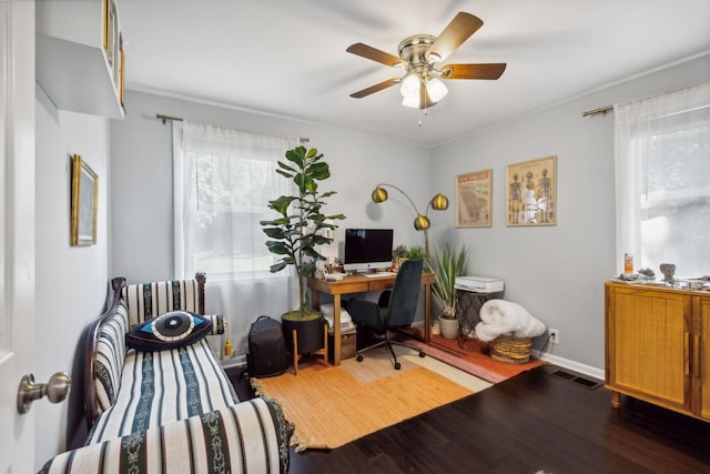 office space featuring plenty of natural light, baseboards, visible vents, and wood finished floors