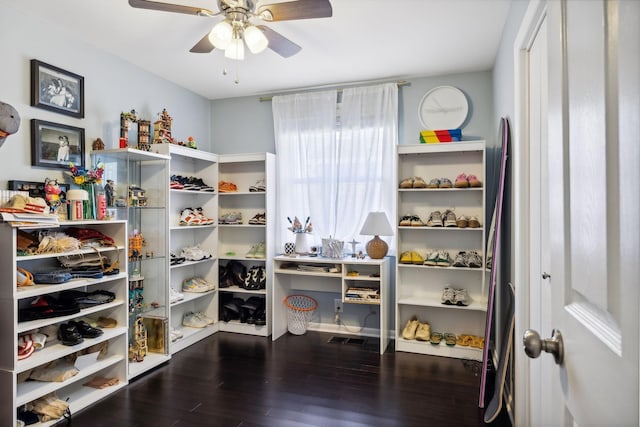 spacious closet with dark wood-style floors and ceiling fan