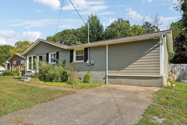 view of side of property featuring brick siding and a yard