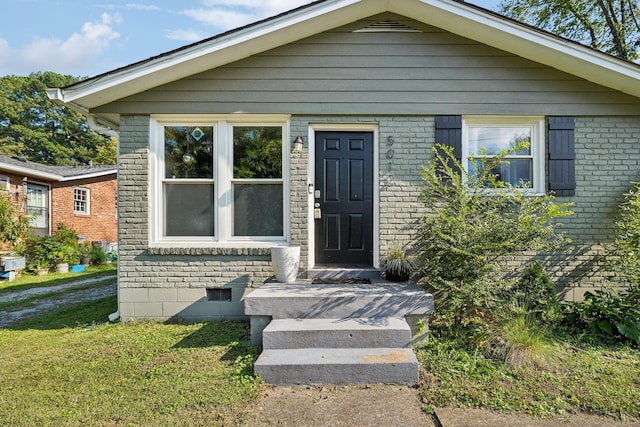 bungalow-style house featuring crawl space, brick siding, and a front yard