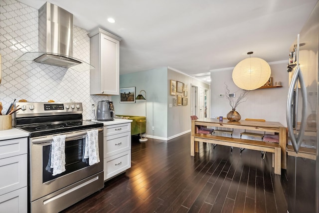 kitchen featuring stainless steel appliances, wall chimney exhaust hood, decorative backsplash, and light countertops