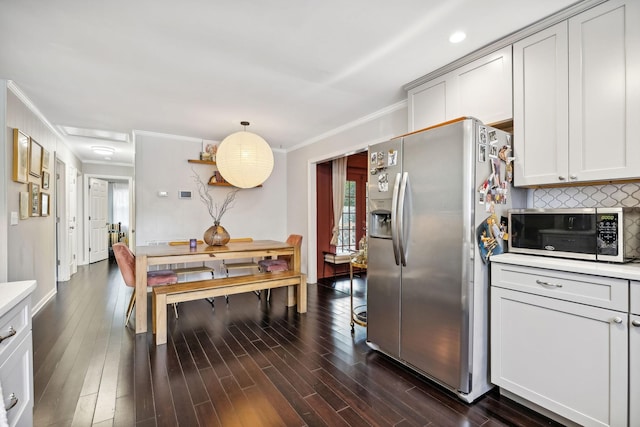 kitchen with crown molding, light countertops, decorative backsplash, appliances with stainless steel finishes, and dark wood-style flooring