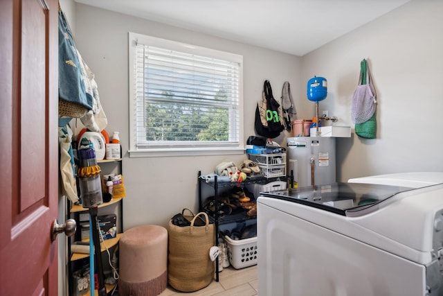 laundry area featuring water heater, laundry area, independent washer and dryer, and wood finished floors