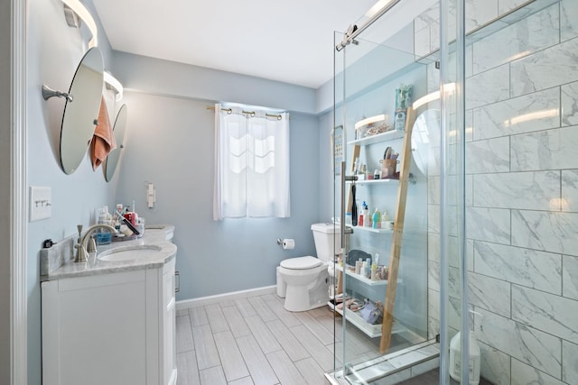 bathroom featuring vanity, baseboards, wood finish floors, a shower stall, and toilet