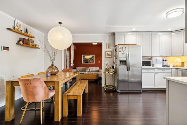 dining room with dark wood-type flooring and crown molding