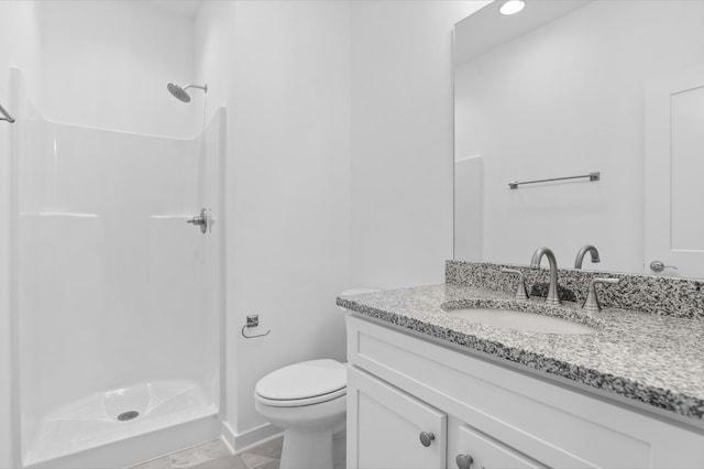 bathroom with toilet, a stall shower, and vanity