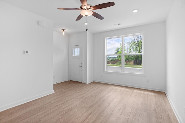 empty room featuring visible vents, baseboards, light wood finished floors, and ceiling fan