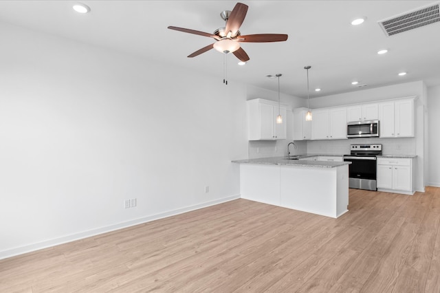 kitchen with visible vents, a sink, decorative backsplash, appliances with stainless steel finishes, and light wood-type flooring