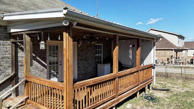 exterior space featuring fence, brick siding, and a shingled roof