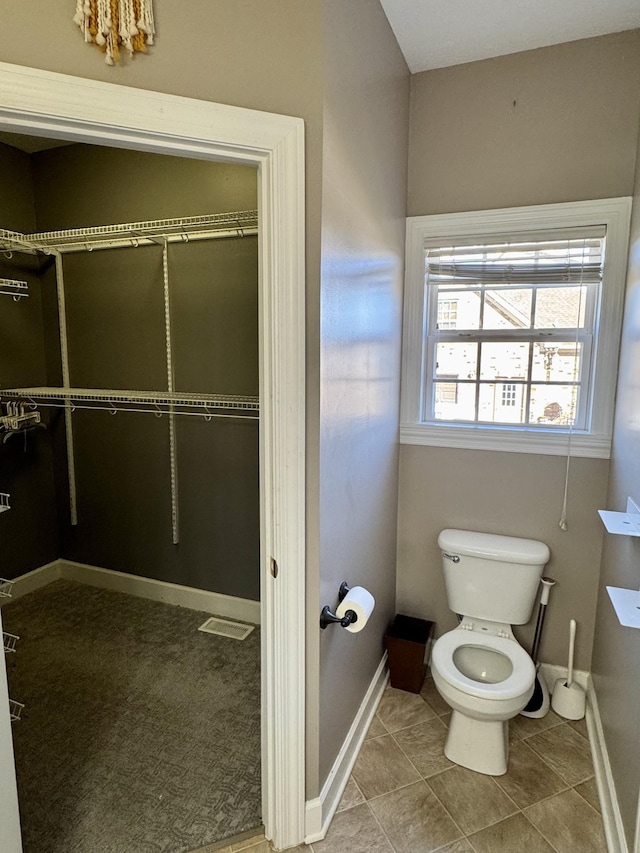 bathroom with tile patterned flooring, toilet, and baseboards