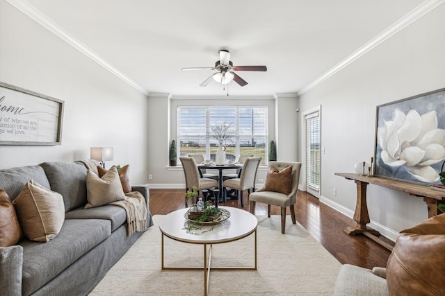 living room featuring ornamental molding, baseboards, and wood finished floors