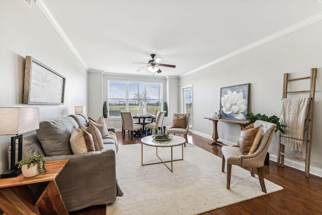 living room with ceiling fan, wood finished floors, baseboards, and ornamental molding