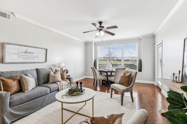 living room featuring crown molding, wood finished floors, and baseboards