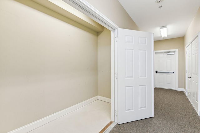 hall featuring baseboards and carpet floors