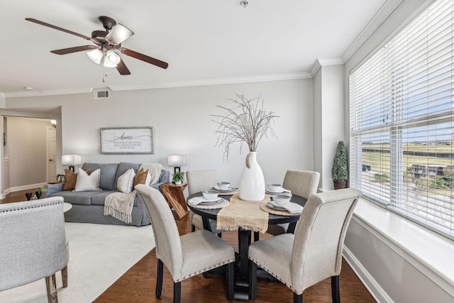 dining room featuring visible vents, baseboards, ceiling fan, dark wood finished floors, and ornamental molding