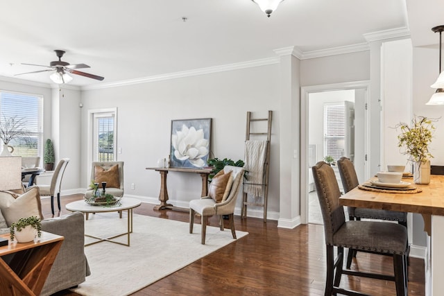 living area featuring dark wood finished floors, a ceiling fan, baseboards, and ornamental molding