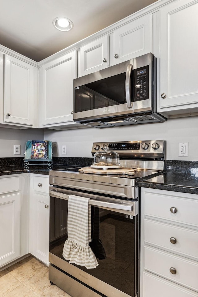 kitchen with recessed lighting, dark stone countertops, appliances with stainless steel finishes, and white cabinetry