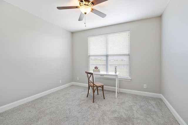 office space featuring baseboards, light carpet, and ceiling fan