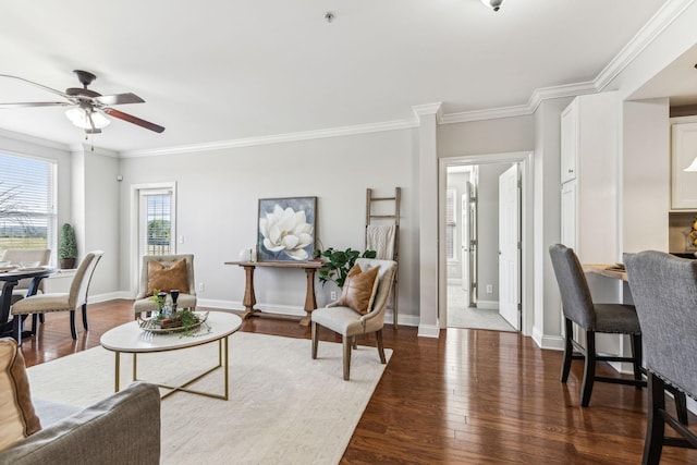 living room featuring a ceiling fan, crown molding, wood finished floors, and baseboards