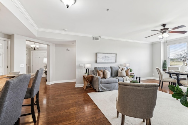 living area featuring visible vents, crown molding, baseboards, and wood finished floors