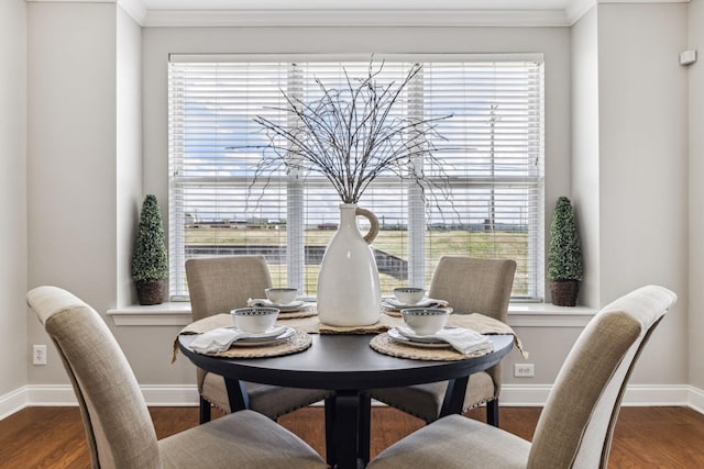 dining space with ornamental molding, baseboards, and wood finished floors