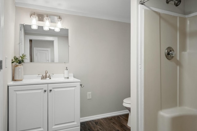 full bathroom featuring vanity, a shower, baseboards, and wood finished floors