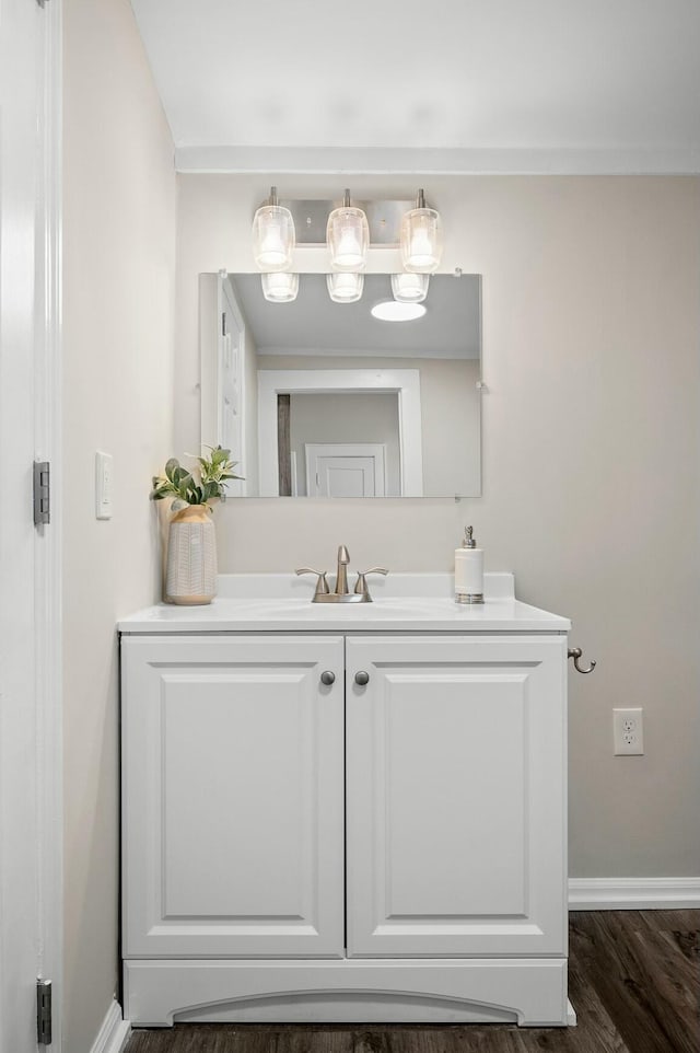 bathroom with baseboards, wood finished floors, and vanity