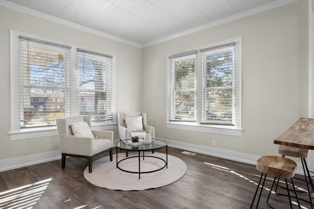 sitting room with visible vents, baseboards, wood finished floors, and ornamental molding