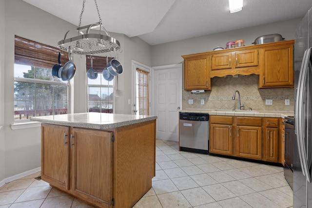 kitchen featuring a sink, backsplash, stainless steel appliances, light countertops, and light tile patterned floors