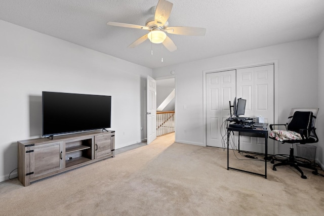 home office featuring a textured ceiling, baseboards, carpet, and a ceiling fan