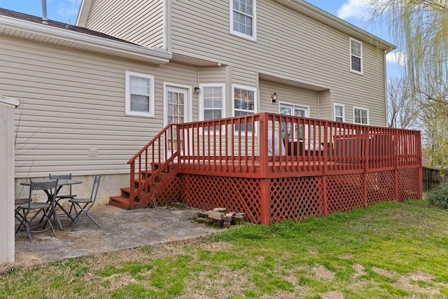 back of property with a patio area, a lawn, and a wooden deck