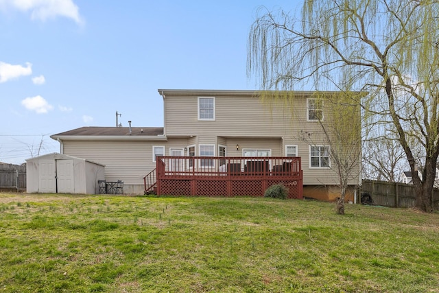 rear view of property featuring an outdoor structure, fence, a lawn, and a shed