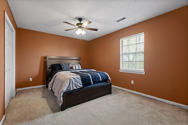 bedroom with visible vents, baseboards, a textured ceiling, and carpet flooring