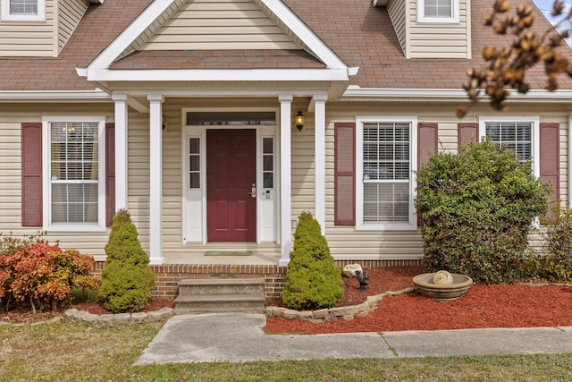 doorway to property with roof with shingles