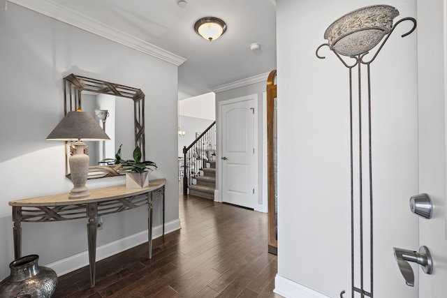 hallway with stairs, crown molding, baseboards, and dark wood-style flooring