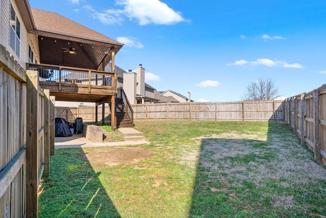 view of yard featuring stairs, a ceiling fan, a fenced backyard, and a wooden deck