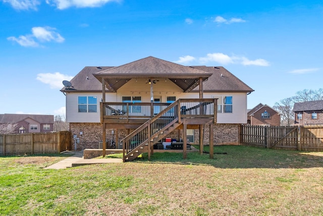 back of house featuring a fenced backyard, stairway, a yard, a wooden deck, and brick siding