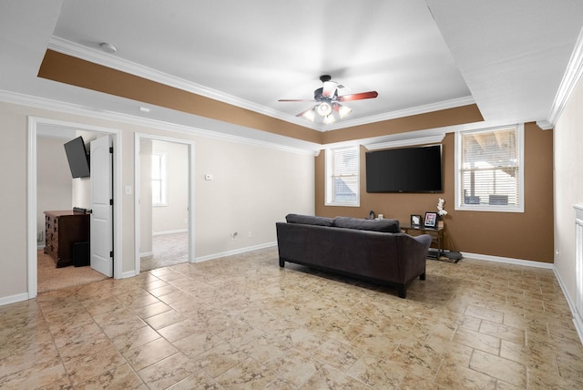 living room featuring a tray ceiling, a wealth of natural light, and ornamental molding