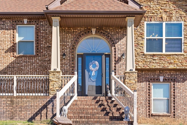 entrance to property with brick siding and roof with shingles