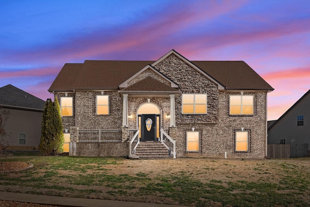 view of front of property with brick siding and roof with shingles