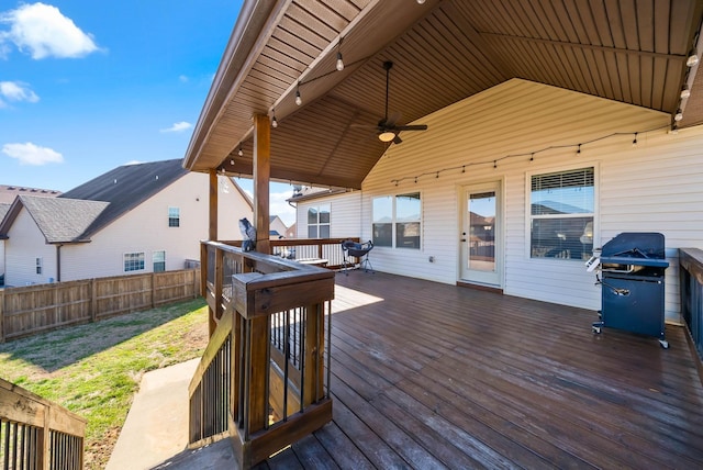 wooden deck with grilling area, a ceiling fan, and fence