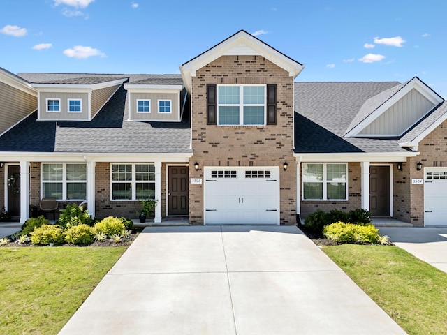 view of front of home with a front yard, brick siding, roof with shingles, and driveway