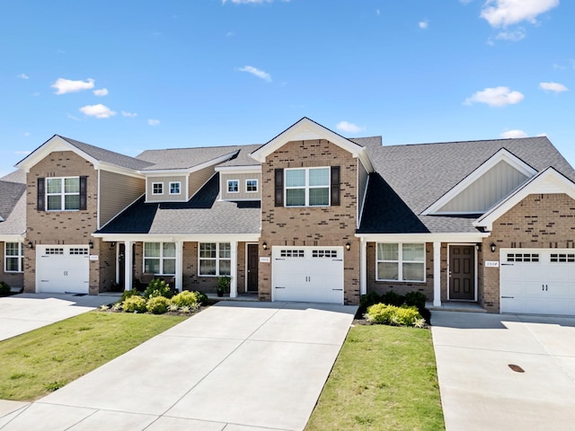 view of front facade featuring a front lawn, driveway, a shingled roof, a garage, and brick siding