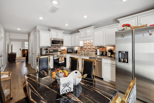 kitchen with visible vents, tasteful backsplash, appliances with stainless steel finishes, and white cabinetry